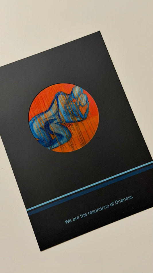 unusual postcard with a circular design featuring a blue couple figure on an orange background, on a black surface.